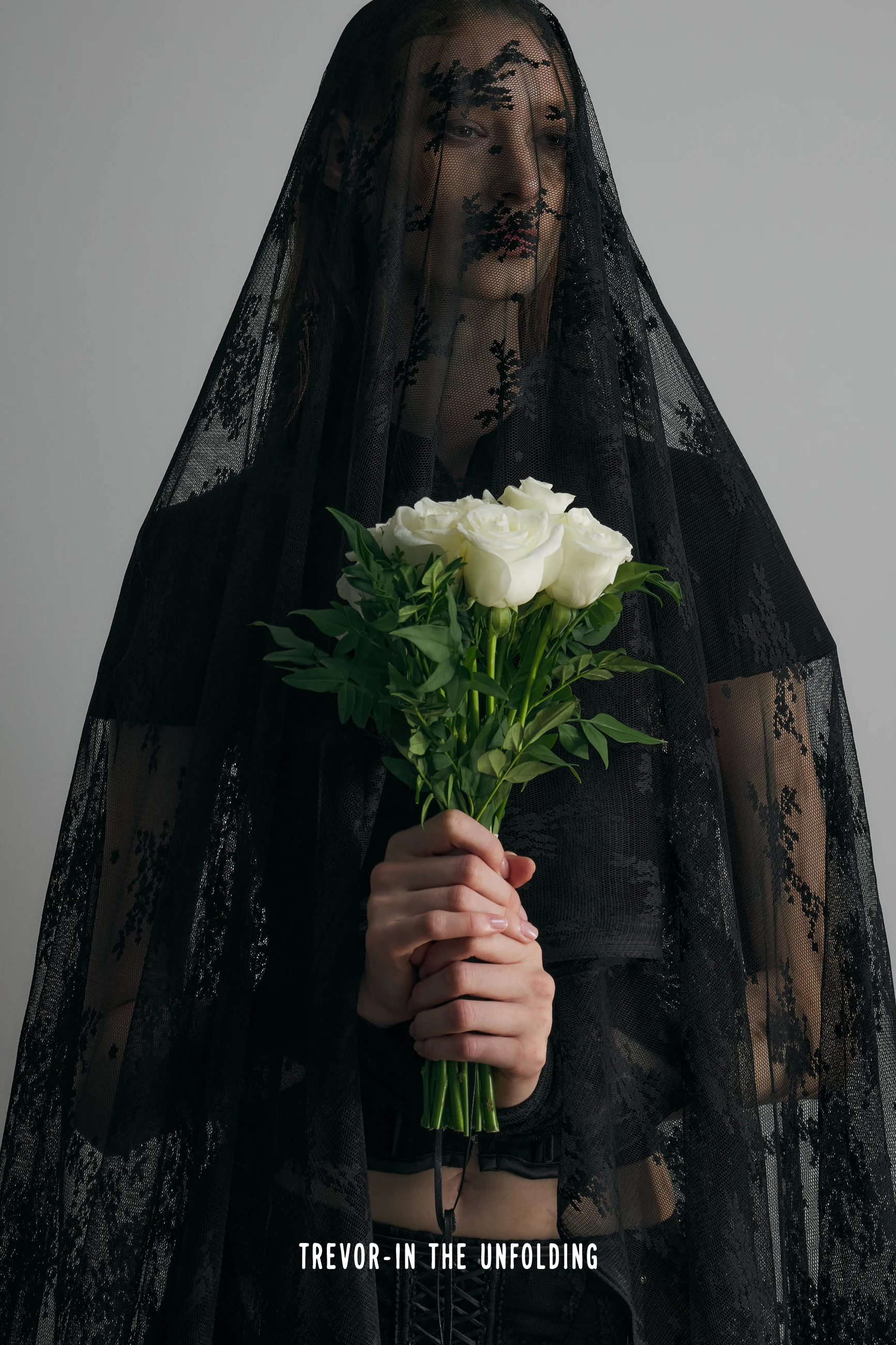 Figure in black lace holding a bouquet of white roses