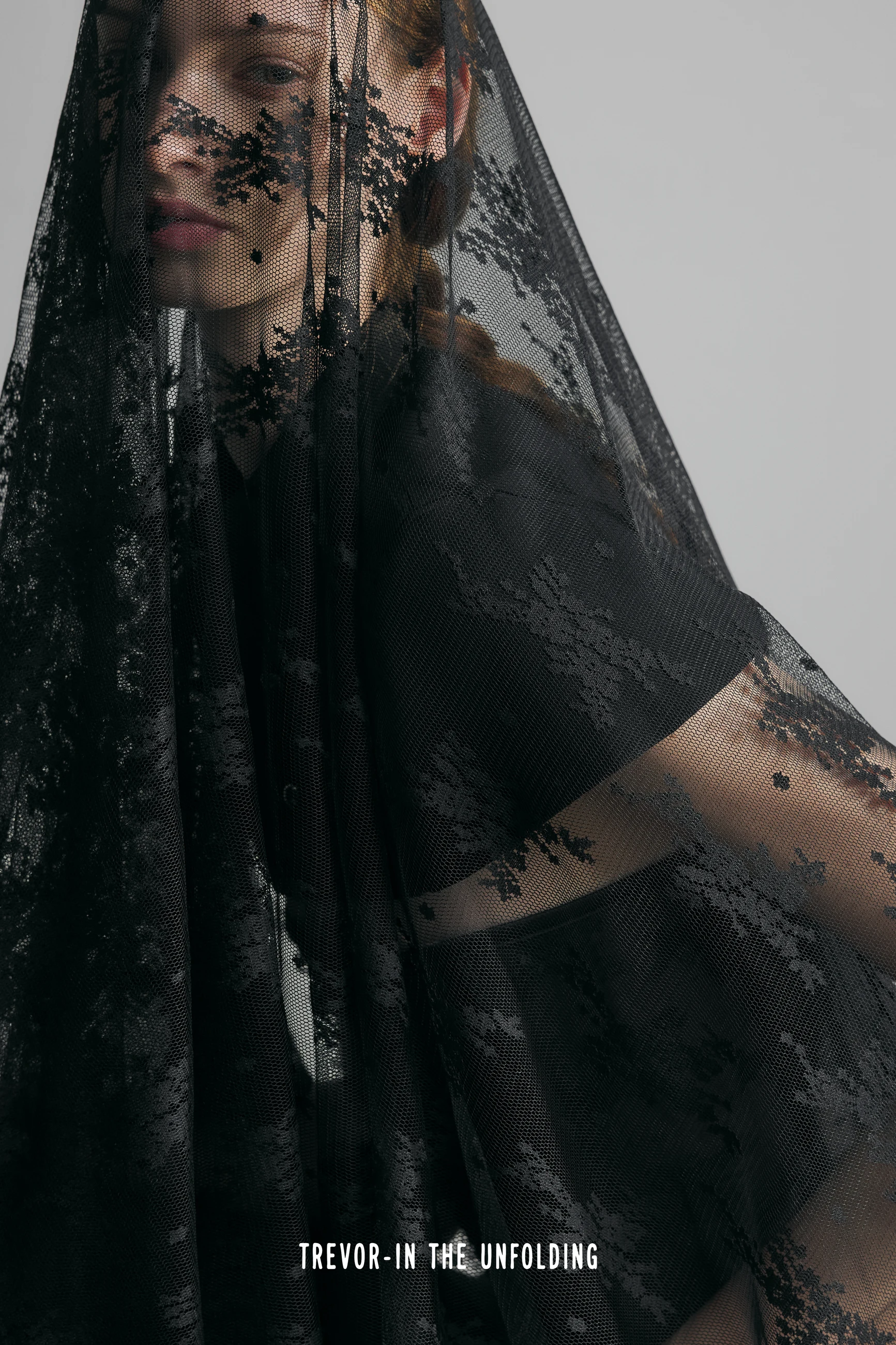 Close portrait through a black floral lace veil
